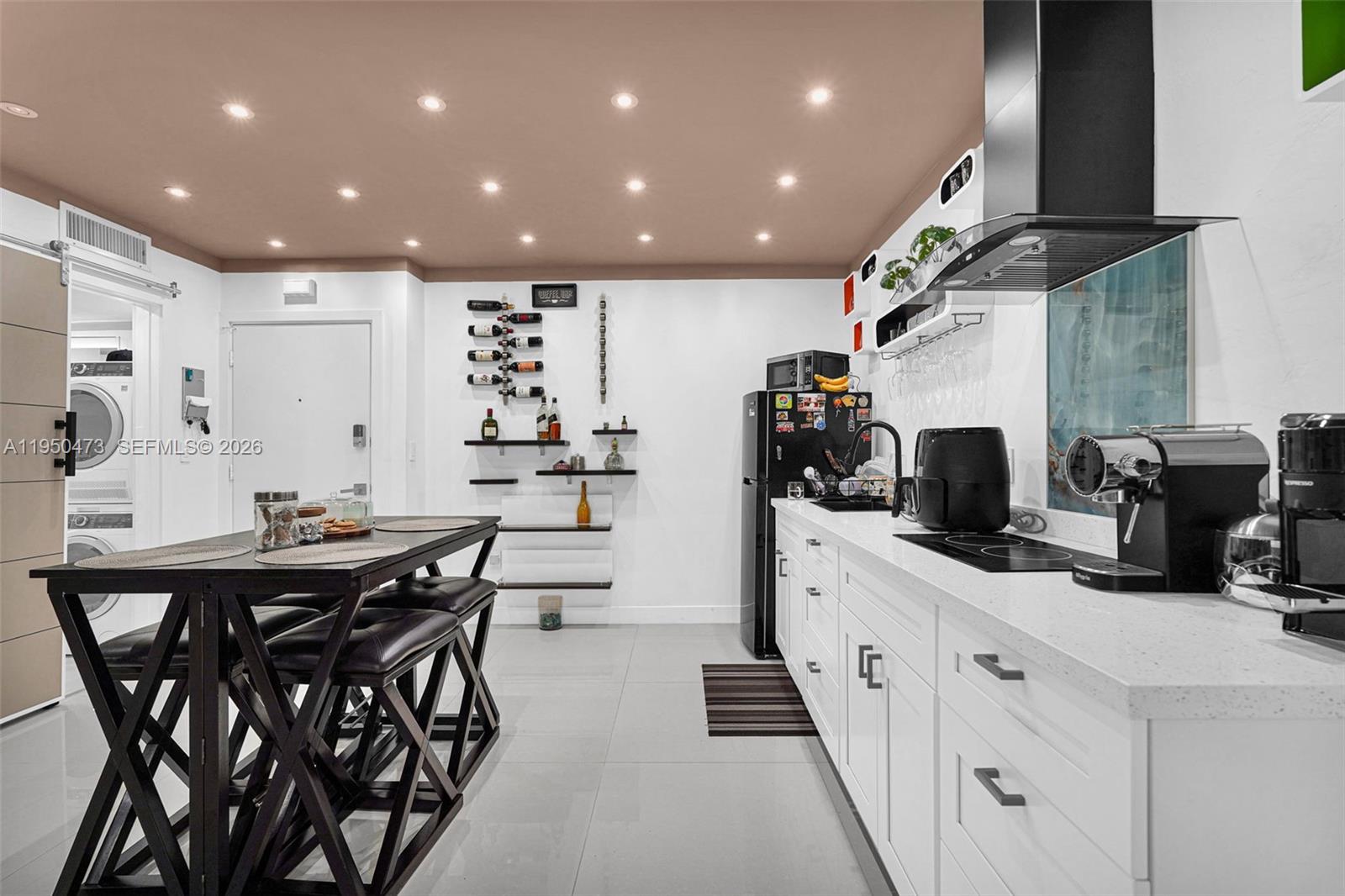 7401 Southwest 82nd Street, Unit 202S Miami, FL 33143 - Photo 7 of 39 a kitchen with stainless steel appliances kitchen island granite countertop a table chairs sink and white cabinets