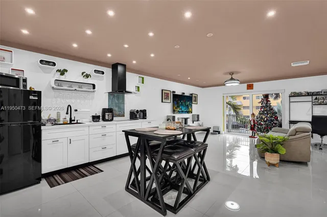 a kitchen with stainless steel appliances kitchen island granite countertop a table and chairs in it
