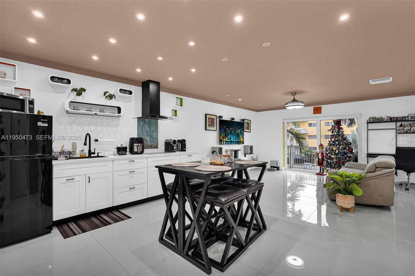 7401 Southwest 82nd Street, Unit 202S Miami, FL 33143 - Photo 9 of 39 a kitchen with stainless steel appliances kitchen island granite countertop a table and chairs in it