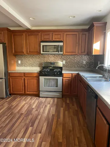 a kitchen with stainless steel appliances granite countertop a sink stove microwave and cabinets