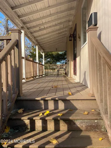 a view of a patio with table and chairs with wooden floor and fence