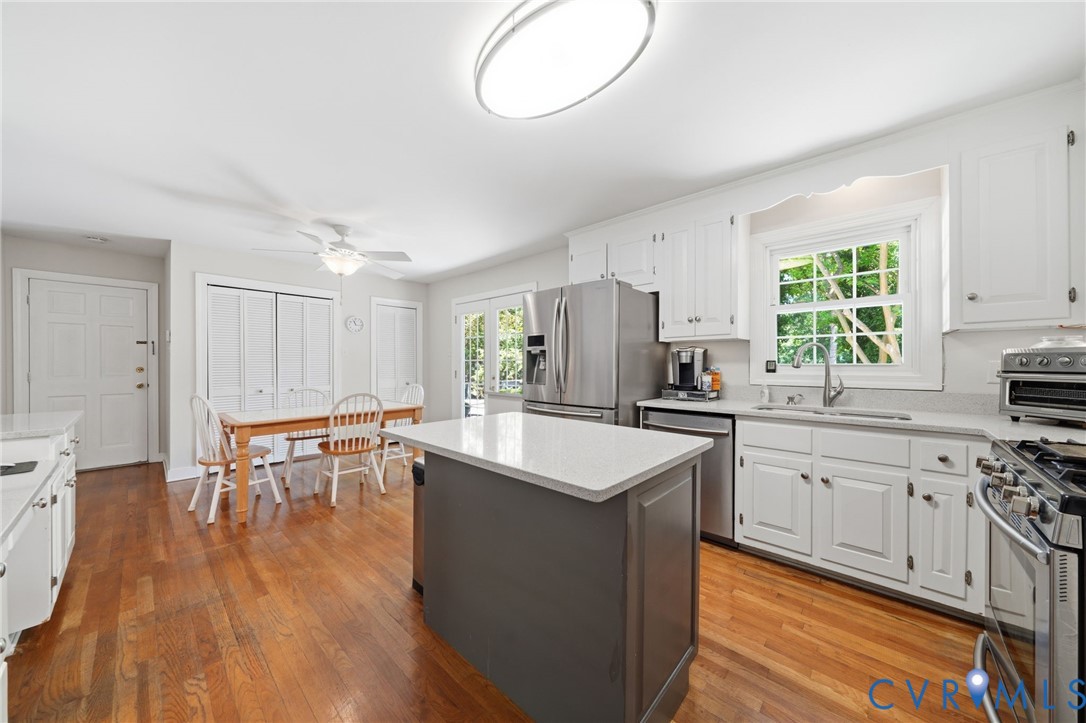 2101 Castlebridge Road Midlothian, VA 23113 - Photo 7 of 37 a kitchen with stainless steel appliances granite countertop a stove top oven a sink dishwasher and a dining table with wooden floors