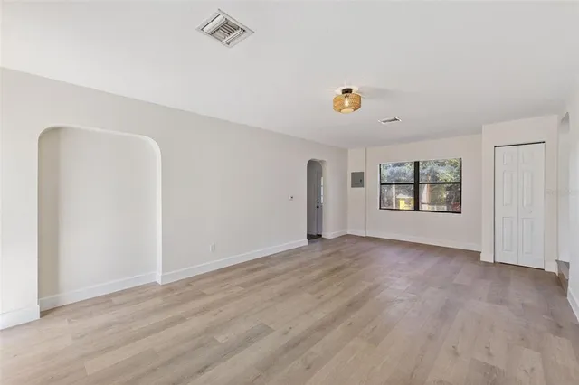 an empty room with windows and flowerpot