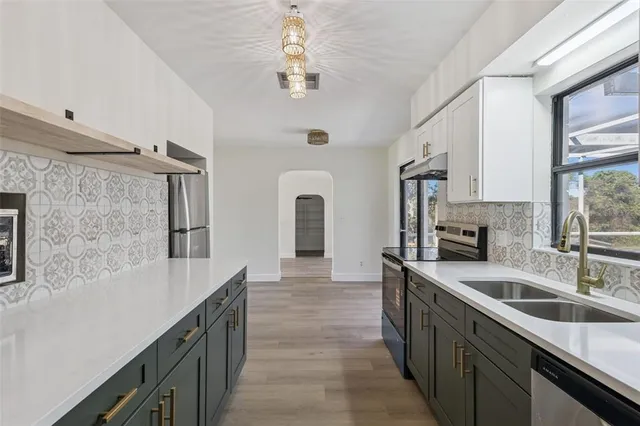 a kitchen with granite countertop a sink dishwasher stove and refrigerator