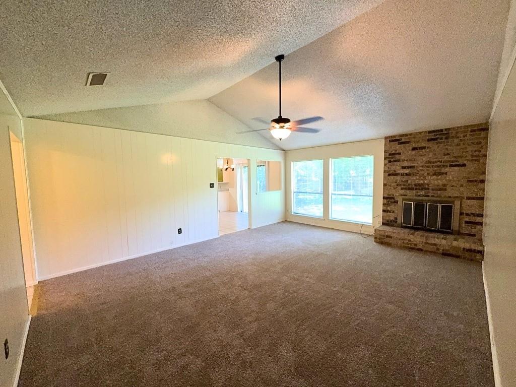 1613 Edgehill Road Benbrook, TX 76126 - Photo 2 of 22 a view of an empty room with a fireplace and a window