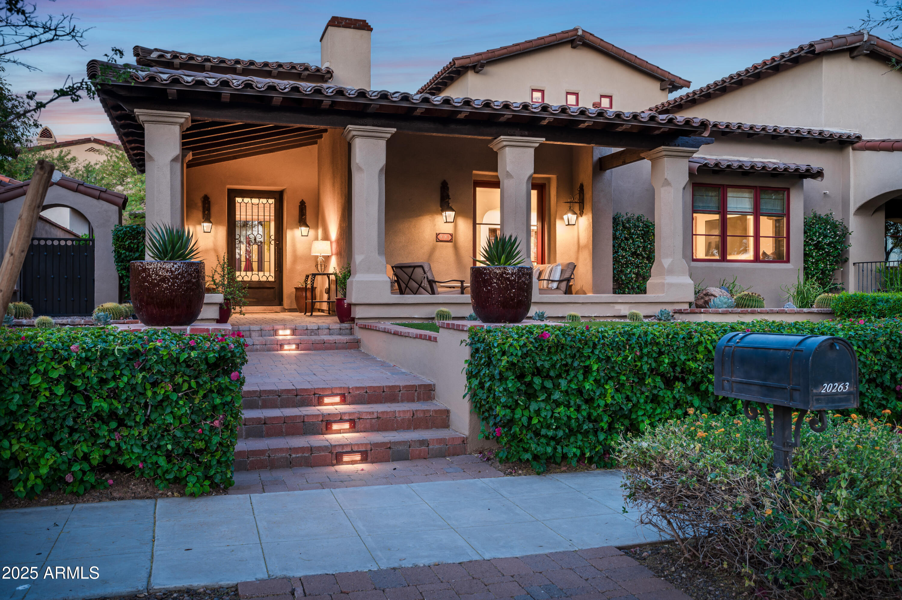 a view of a house with potted plants and a fountain