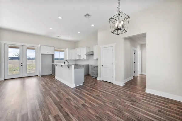 a view of a kitchen with an empty space and wooden floor