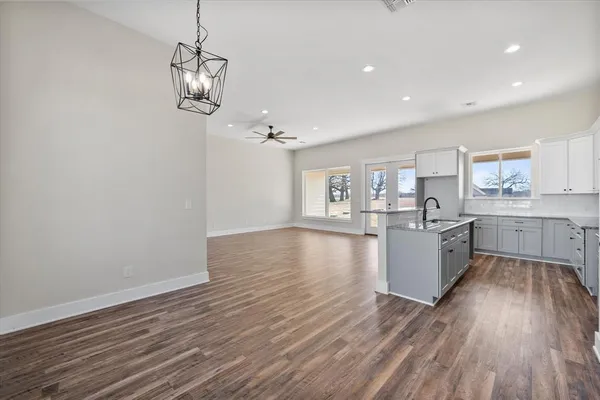 a large kitchen with hardwood floor a sink and appliances