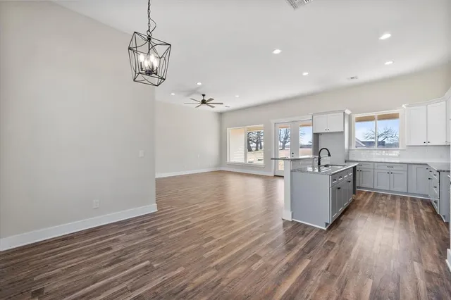 a large kitchen with hardwood floor a sink and appliances