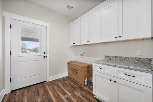 a kitchen with granite countertop white cabinets and sink