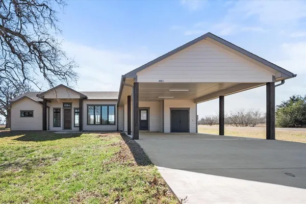 a front view of a house with a yard and potted plants