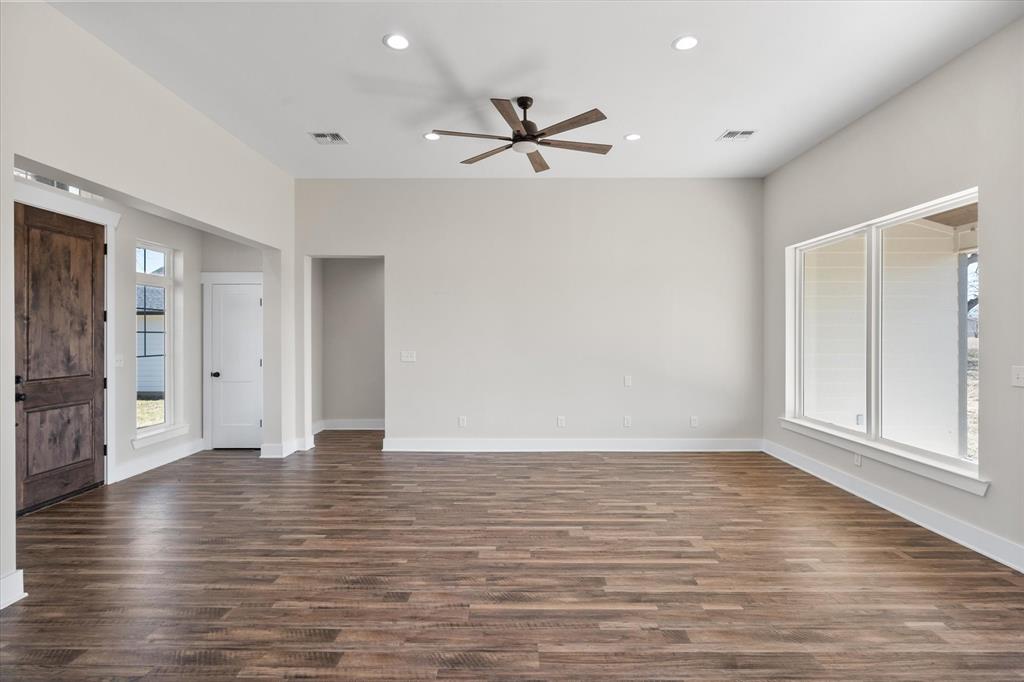 4003 Nettle Road Streetman, TX 75859 - Photo 4 of 33 a view of an empty room with wooden floor and a window