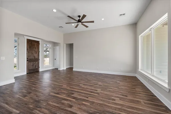 a view of empty room with wooden floor and window