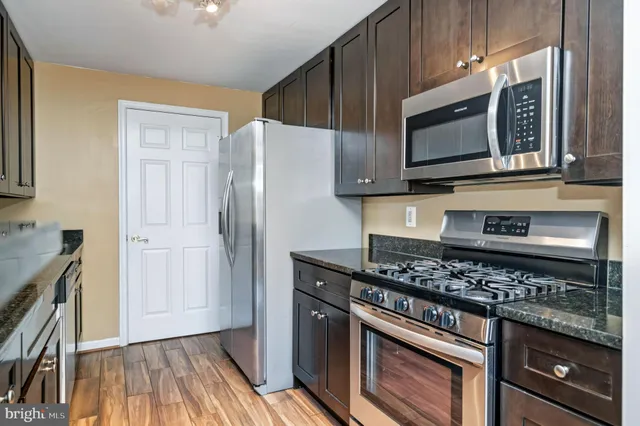 a kitchen with stainless steel appliances granite countertop a stove microwave and refrigerator