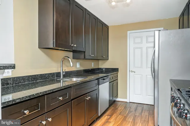 a kitchen with granite countertop wooden cabinets and a sink