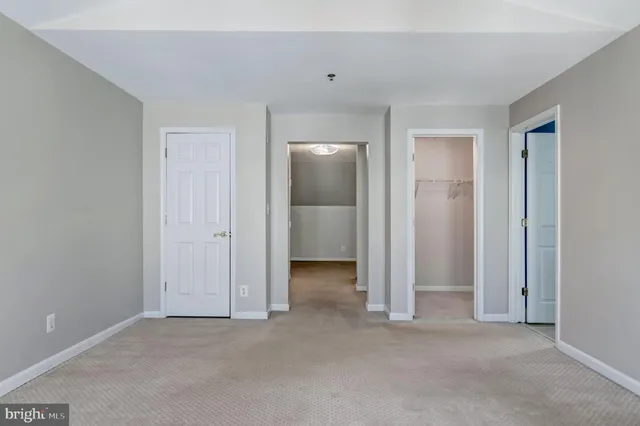an empty room with closet and a bathroom