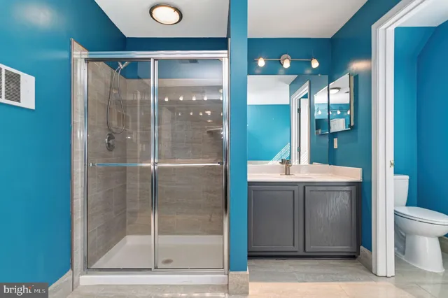 a bathroom with a granite countertop sink mirror and toilet
