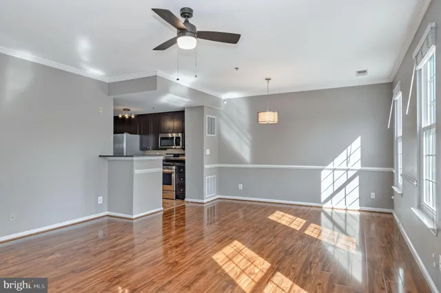 a view of empty room with wooden floor and window