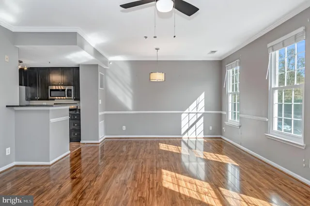 a view of a livingroom with wooden floor and a ceiling fan