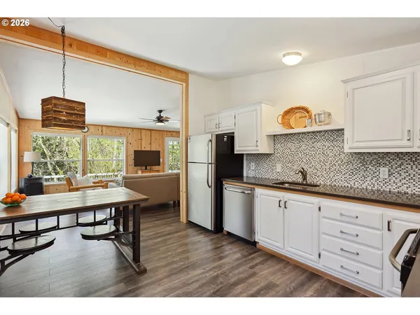 a kitchen with a wooden floor and a refrigerator