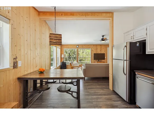 a kitchen with stainless steel appliances a table chairs and a refrigerator
