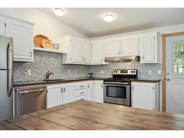 a kitchen with stainless steel appliances granite countertop a sink and cabinets