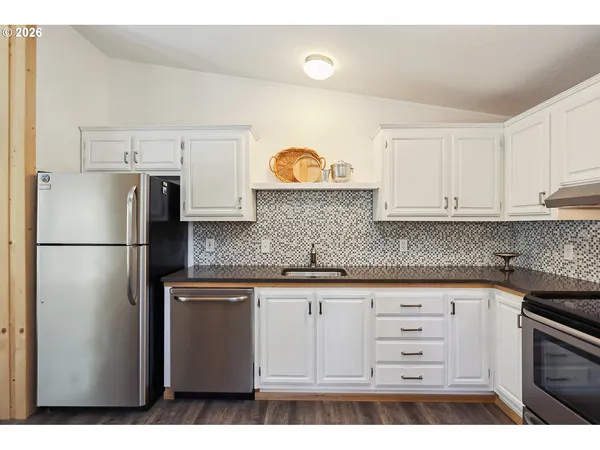 a kitchen with stainless steel appliances granite countertop a refrigerator sink and cabinets