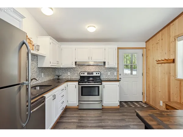 a kitchen with stainless steel appliances granite countertop a stove a sink and a refrigerator