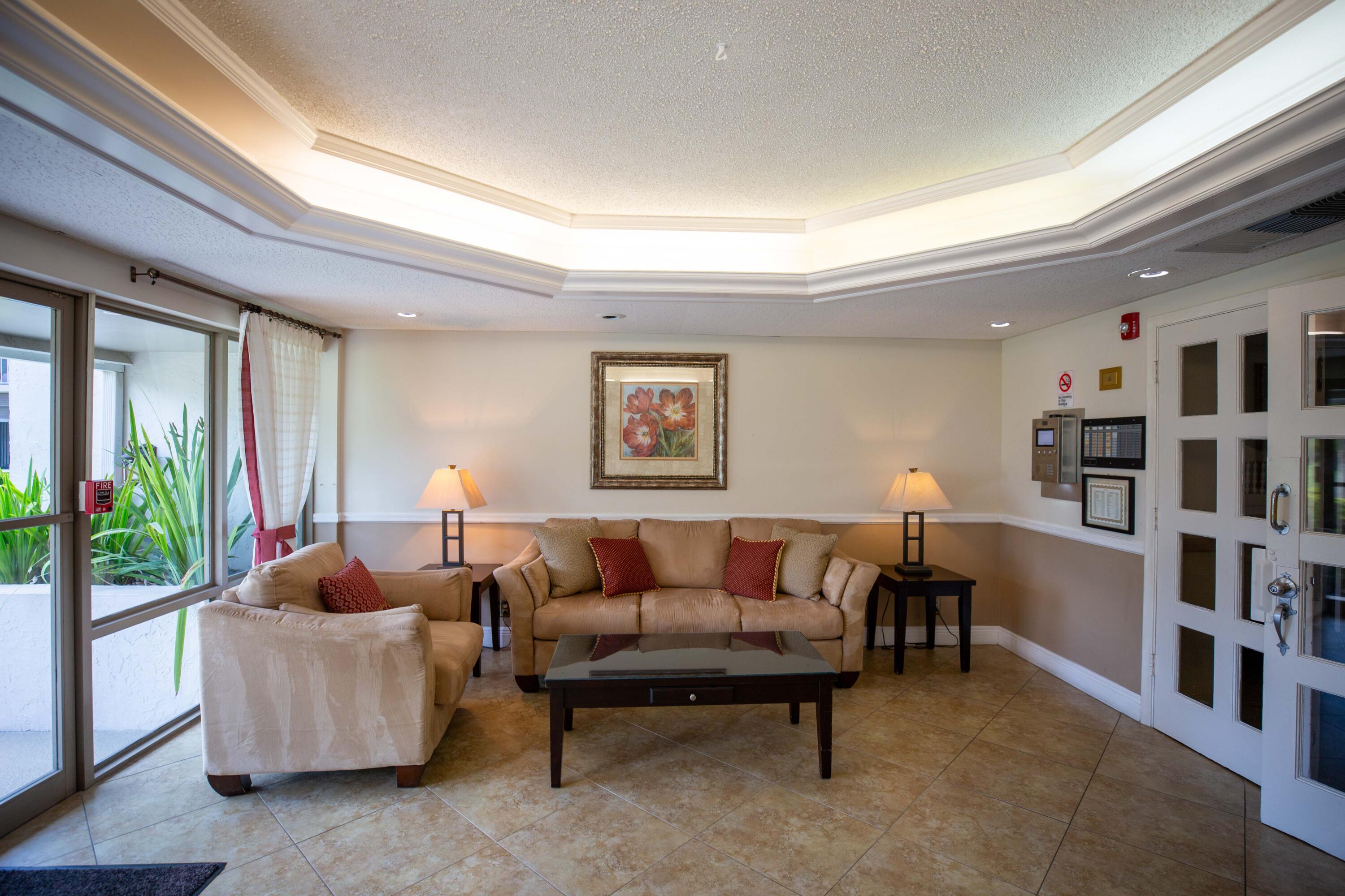 250 Northeast 20th Street, Unit 124S Boca Raton, FL 33431 - Photo 3 of 14 a living room with furniture and a book shelf