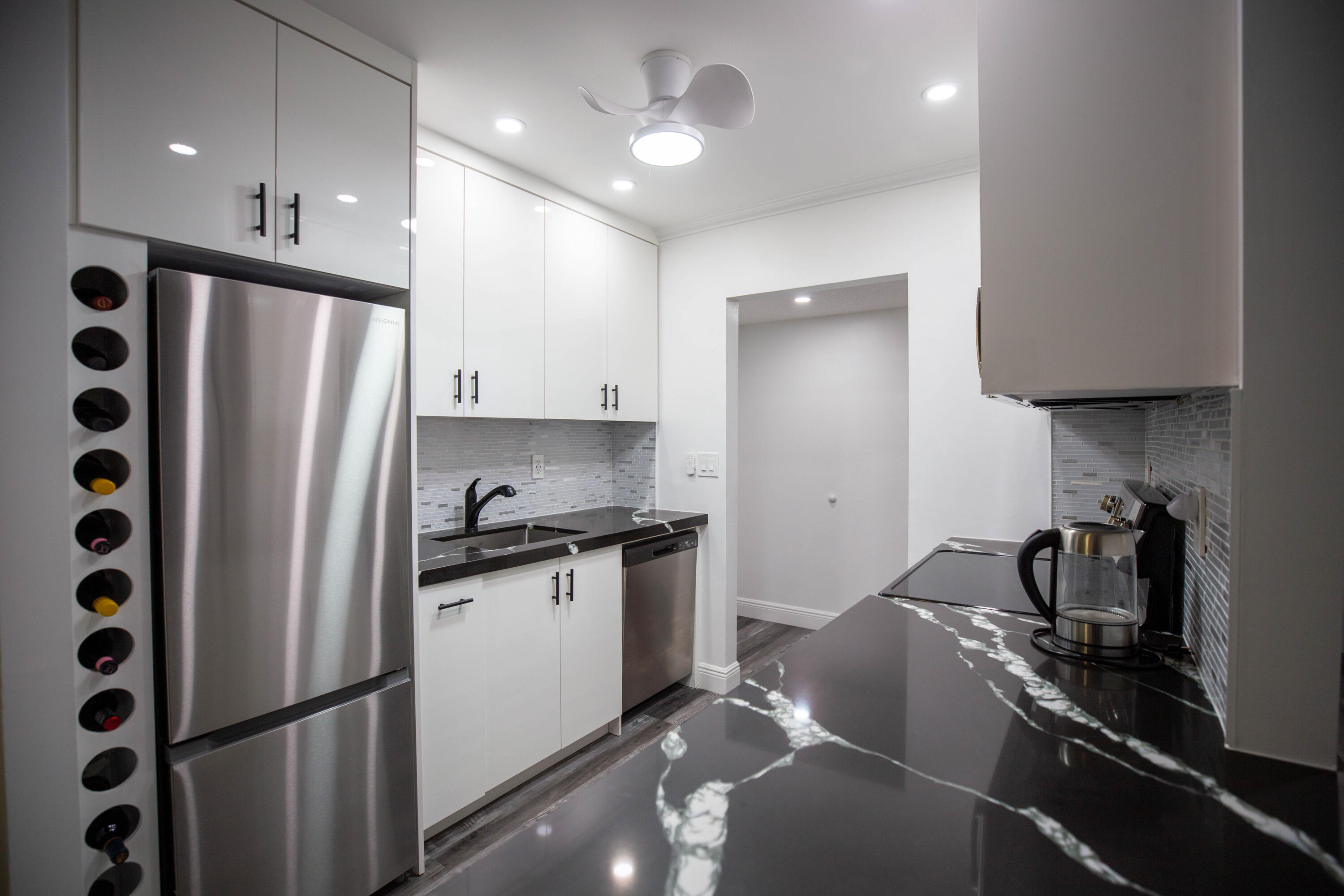 250 Northeast 20th Street, Unit 124S Boca Raton, FL 33431 - Photo 4 of 14 a kitchen with stainless steel appliances granite countertop a refrigerator a sink and a stove with wooden floor