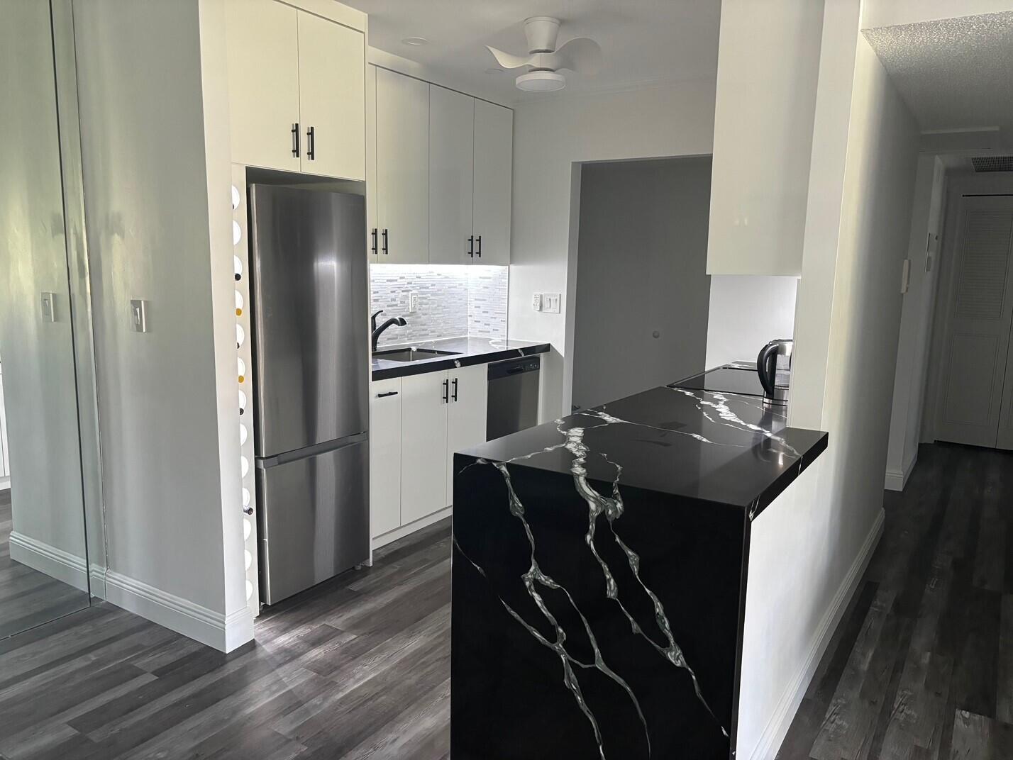 250 Northeast 20th Street, Unit 124S Boca Raton, FL 33431 - Photo 5 of 14 a kitchen with a refrigerator and a sink