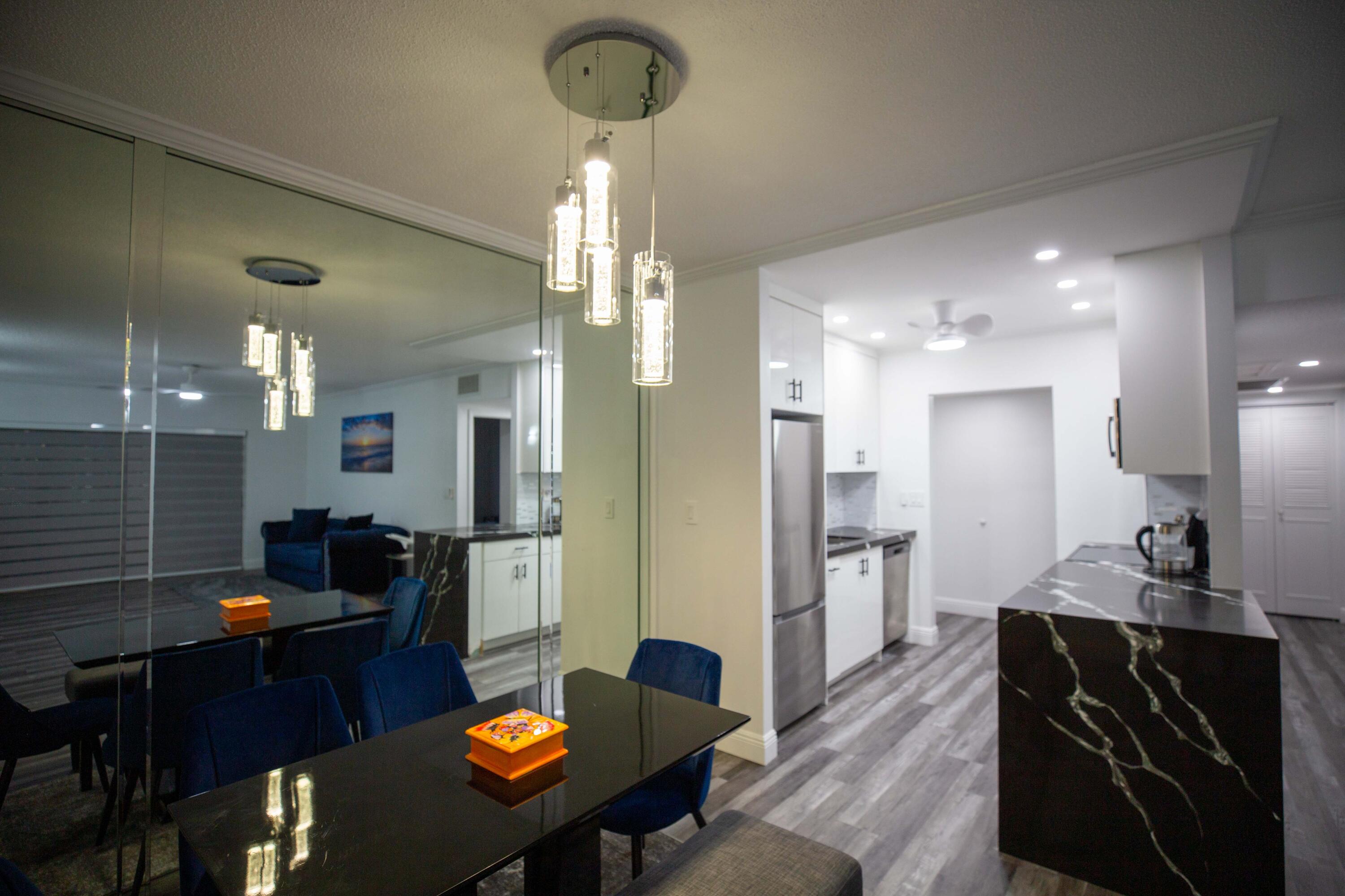 250 Northeast 20th Street, Unit 124S Boca Raton, FL 33431 - Photo 6 of 14 a kitchen with refrigerator and chairs