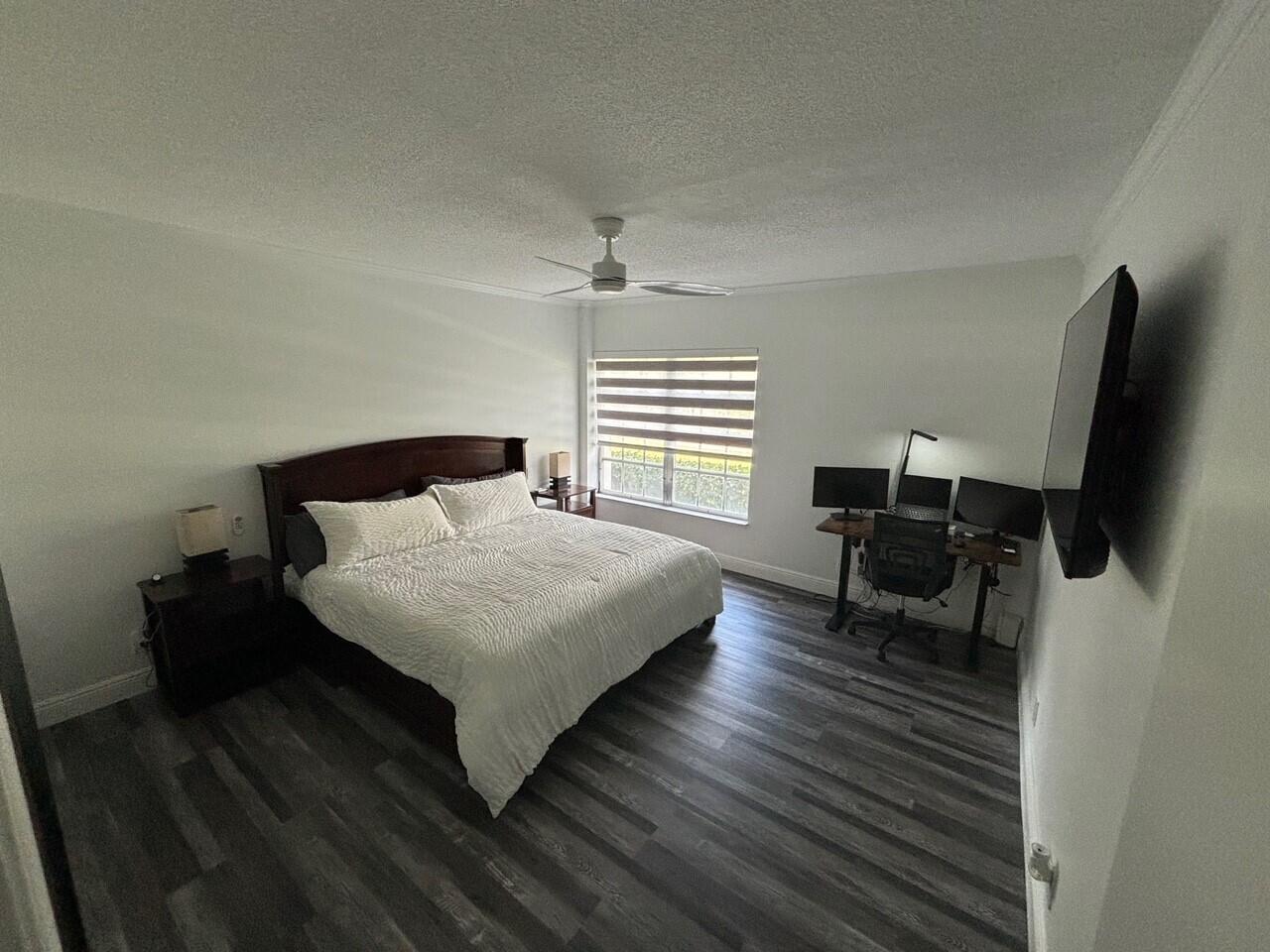 250 Northeast 20th Street, Unit 124S Boca Raton, FL 33431 - Photo 8 of 14 a bedroom with a bed and a flat screen tv