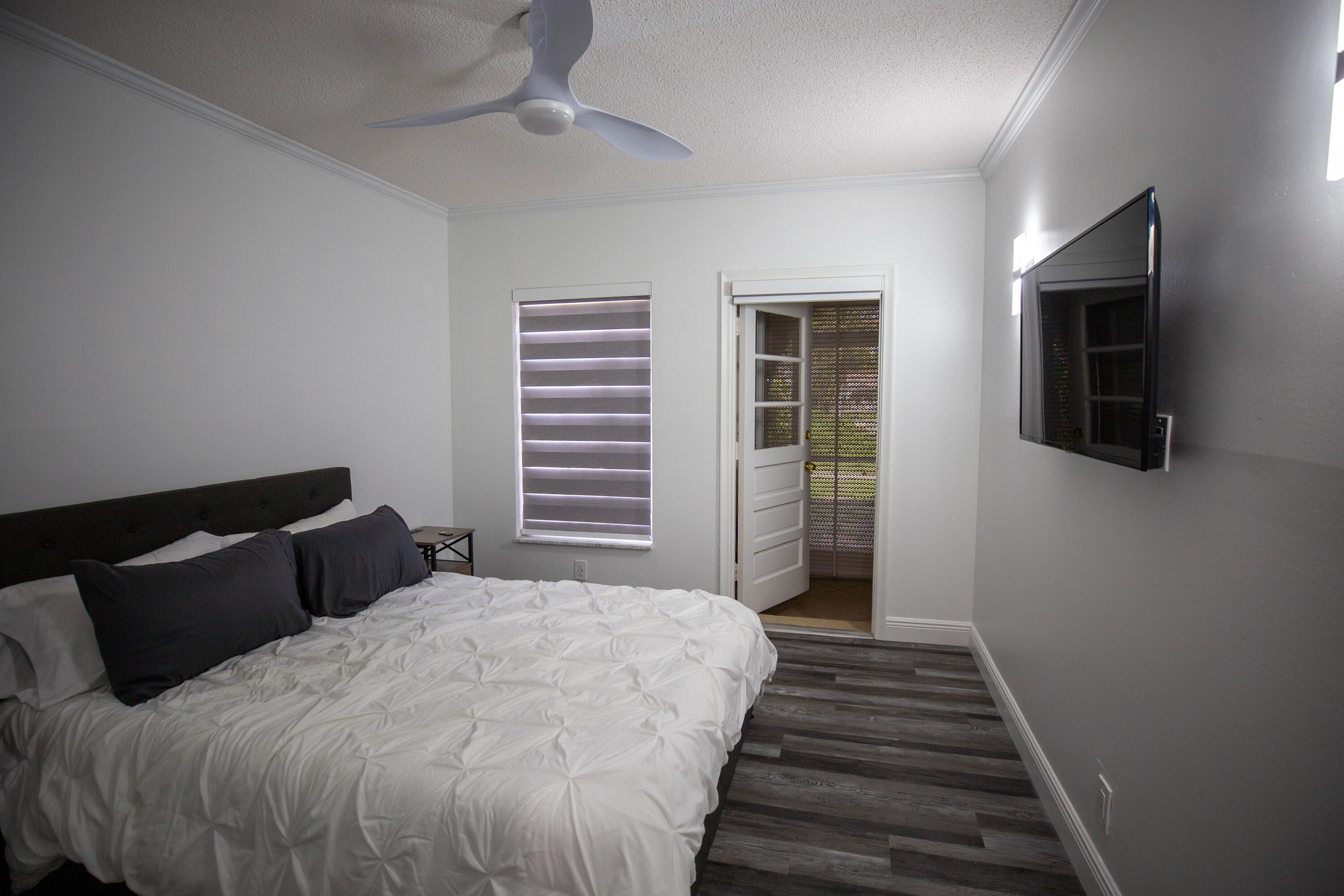 250 Northeast 20th Street, Unit 124S Boca Raton, FL 33431 - Photo 9 of 14 a bedroom with a bed and wooden floor