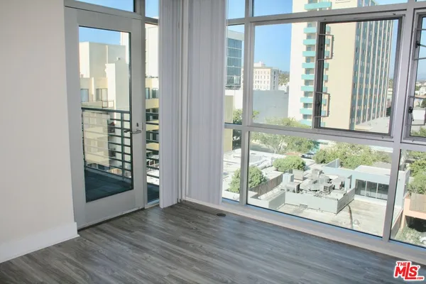 an empty room with wooden floor and a window