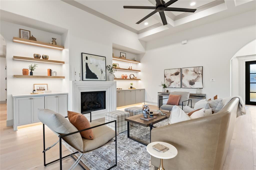 724 Cooper Trail Weatherford, TX 76087 - Photo 12 of 40 Living area with light wood-style floors, a fireplace, arched walkways, beam ceiling, and coffered ceiling