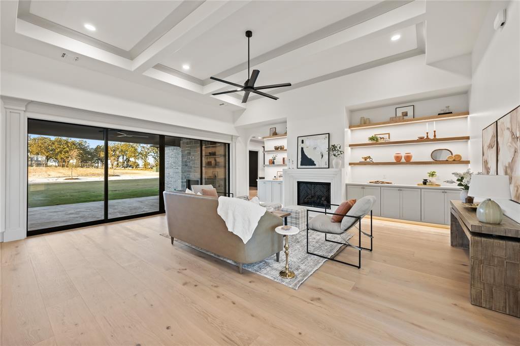 724 Cooper Trail Weatherford, TX 76087 - Photo 10 of 40 Living area featuring beam ceiling, a fireplace, light wood-style flooring, and a ceiling fan