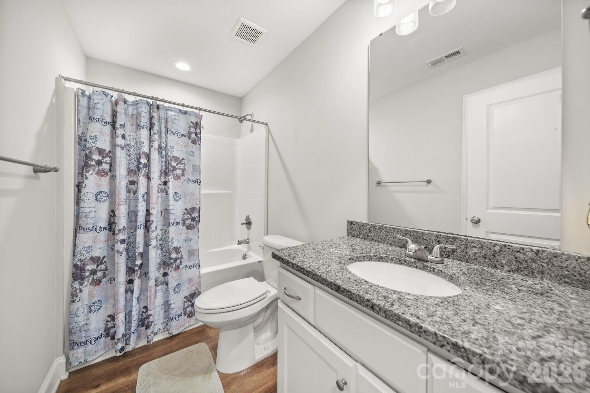 5311 Flint Ridge Marshville, NC 28103 - Photo 20 of 38 a bathroom with a granite countertop sink toilet a mirror and shower curtain