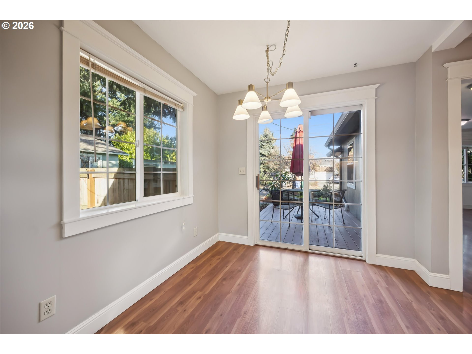6118 Northeast Alton Street Portland, OR 97213 - Photo 21 of 46 a dining room with wooden floor a chandelier a wooden table and chairs
