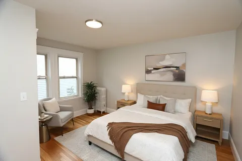 a bedroom with a bed and wooden floor