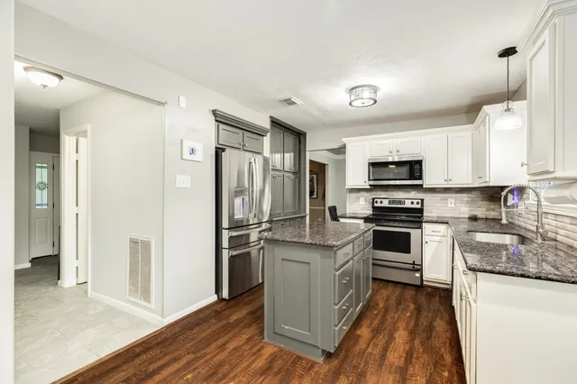 a kitchen with white cabinets and stainless steel appliances