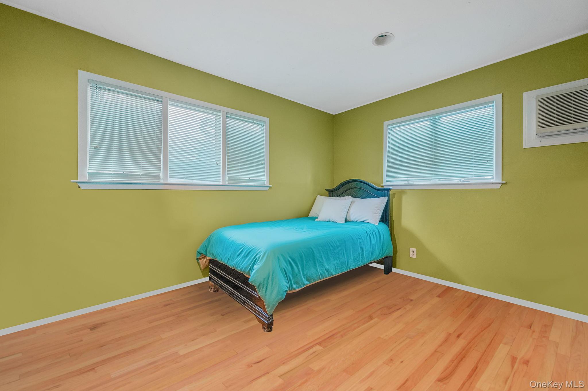 194 Central Park Road Plainview, NY 11803 - Photo 14 of 19 Bedroom featuring light wood finished floors and a wall mounted air conditioner