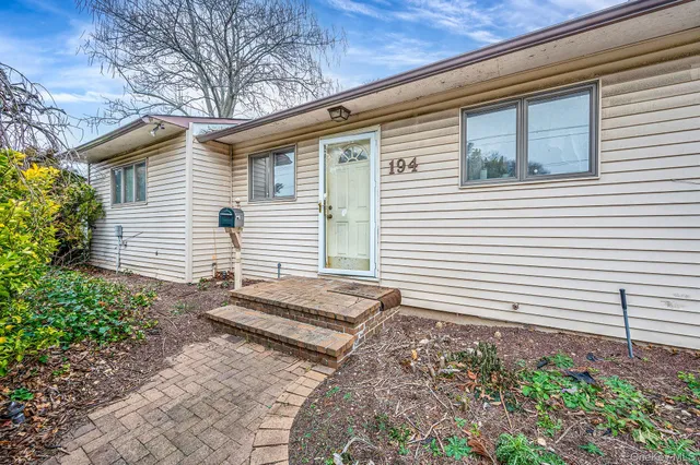 a view of a house with a yard and sitting area