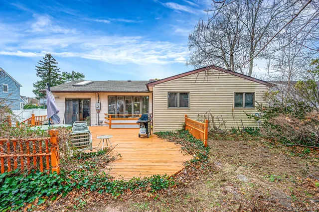 a front view of house with outdoor seating and covered with trees