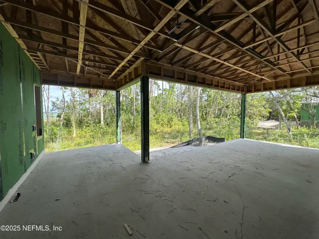 a view of a backyard with large tree and wooden fence
