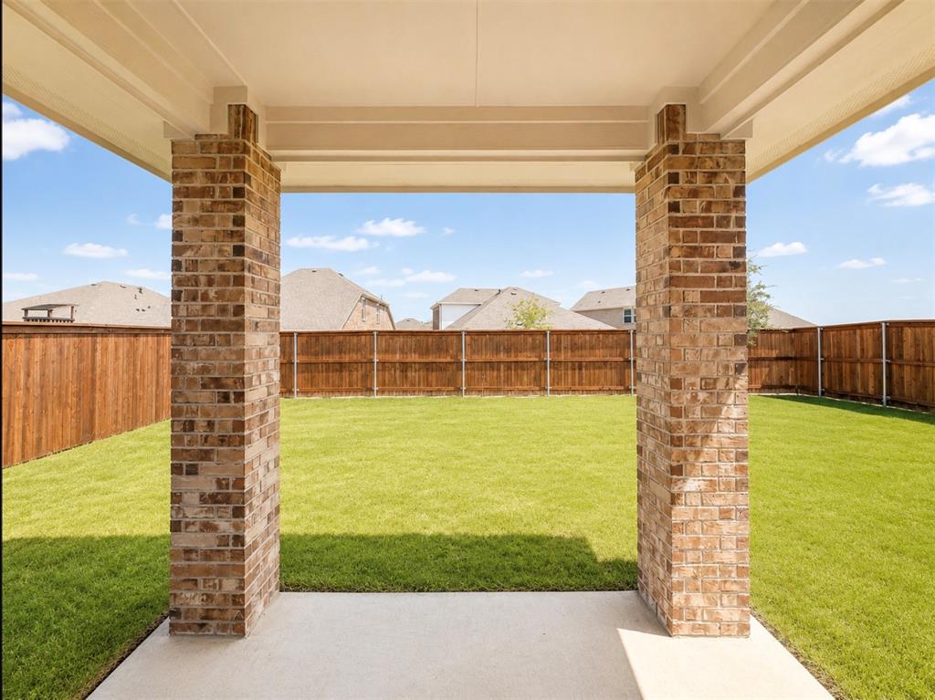 631 Cari Lane Forney, TX 75126 - Photo 15 of 17 Covered patio with a concrete surface, brick columns, and a fully fenced backyard featuring a manicured lawn