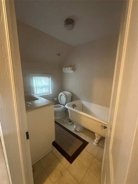 504 1st Street Terrell, TX 75160 - Photo 17 of 27 Bathroom featuring a clawfoot tub, white vanity, and tiled flooring