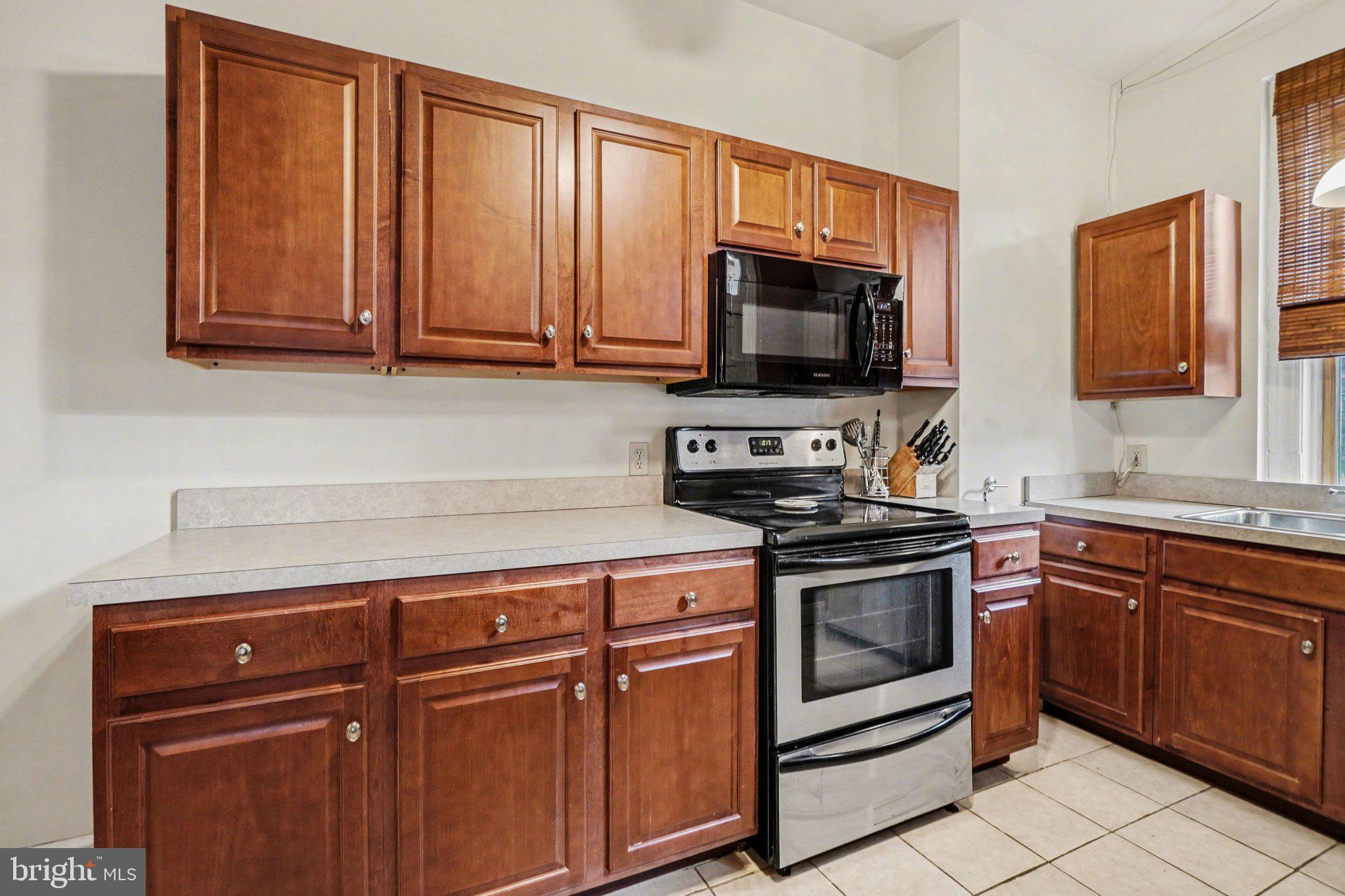 261 Delaware Street Harrisburg, PA 17102 - Photo 10 of 40 a kitchen with granite countertop wooden cabinets and stainless steel appliances