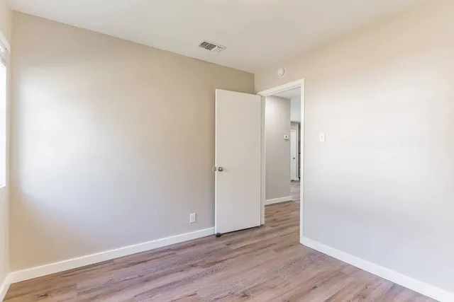 a view of an empty room with wooden floor
