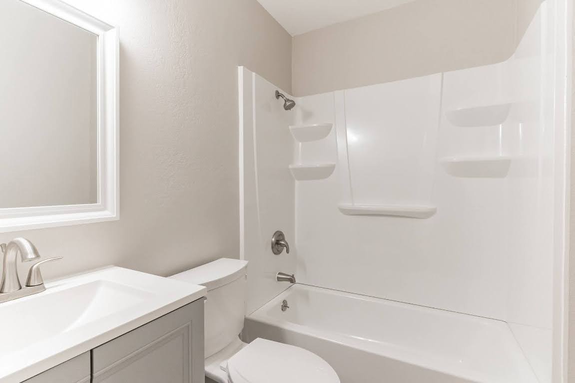 401 Hedgewood Drive, Unit D Georgetown, TX 78628 - Photo 17 of 19 a bathroom with a sink toilet vanity and shower